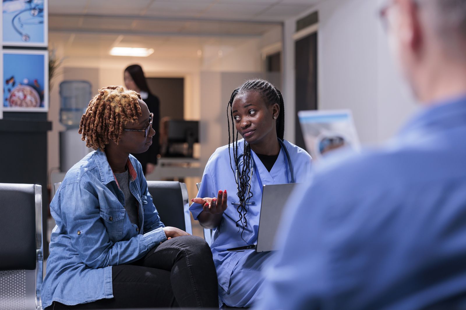A nurse talking a patient through her results in a clinic lobby