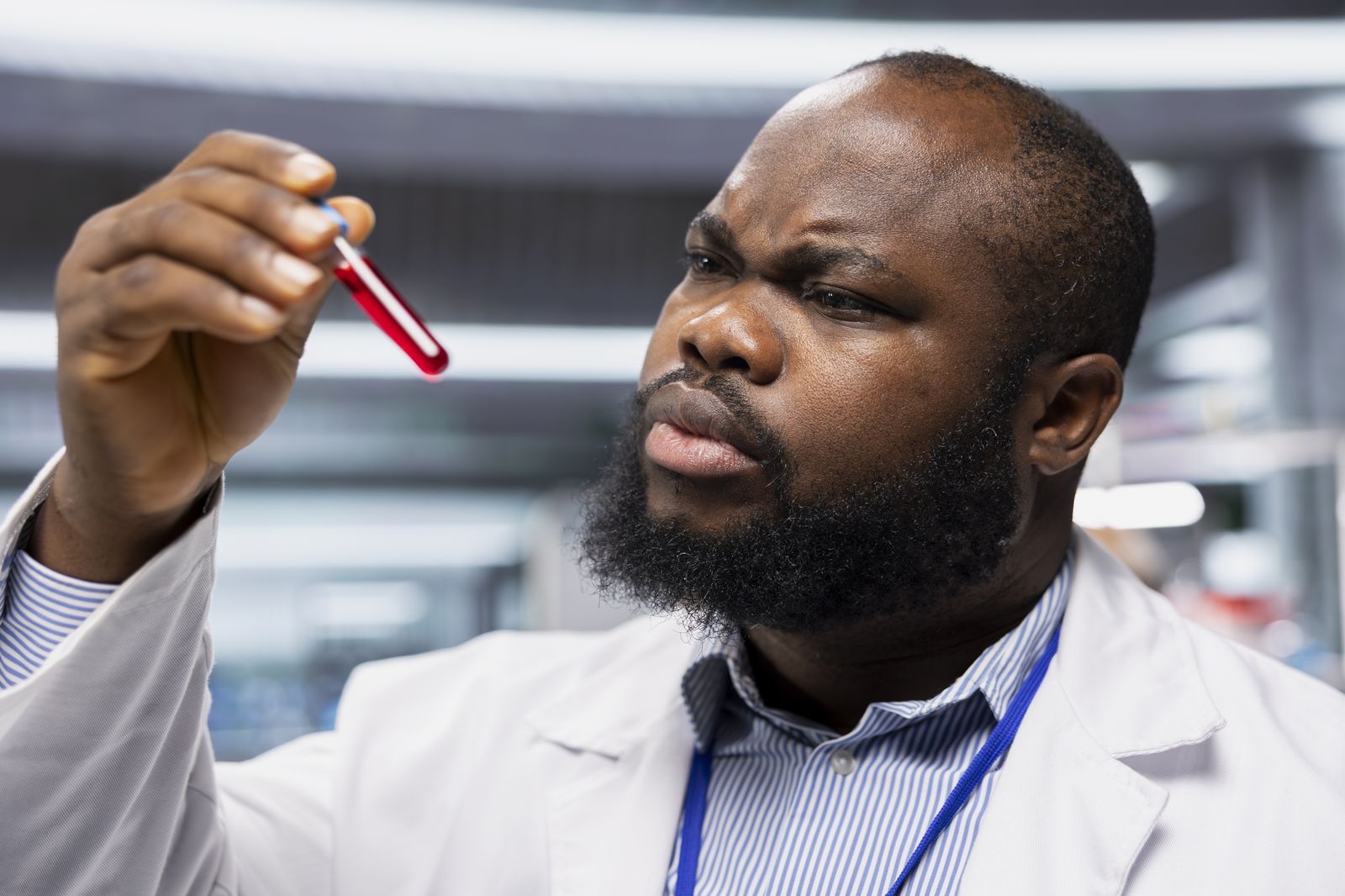 A lab scientist checking a blood sample tube