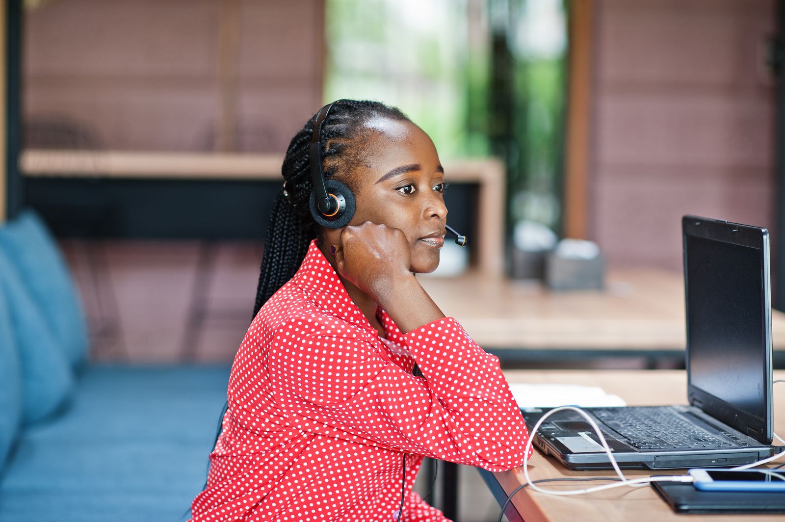 A support agent wearing a headset at her laptop