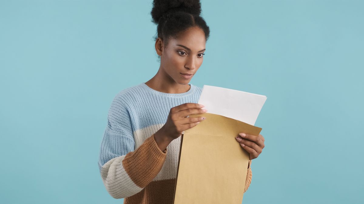 A woman opening an envelope of paper test results